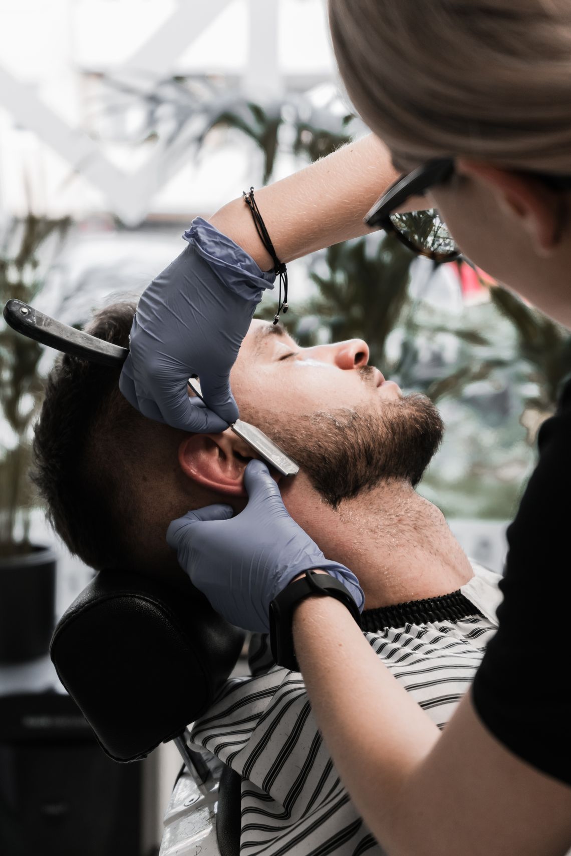 Professional barber performing precise beard grooming