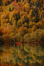 Autumn landscape with red boat on lake