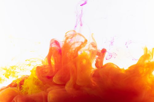 Free Colorful ink swirls in water create a vivid abstract design with orange and yellow hues. Stock Photo