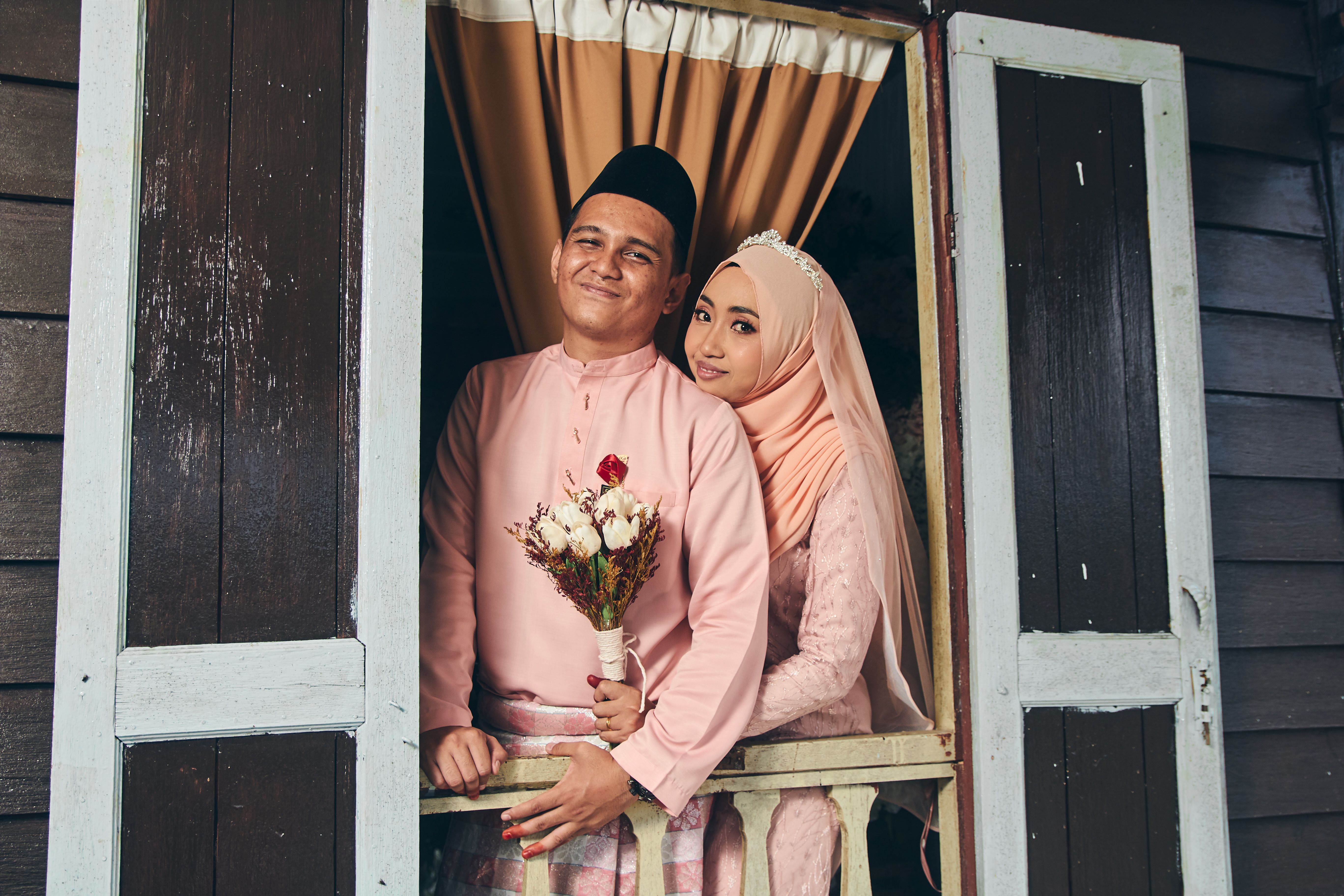 A beautiful Malay couple in traditional attire, capturing a romantic moment on their wedding day.