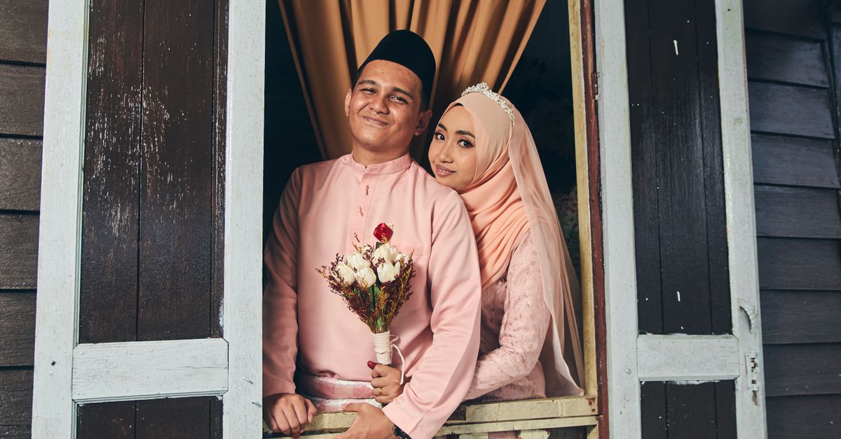 A beautiful Malay couple in traditional attire, capturing a romantic moment on their wedding day.