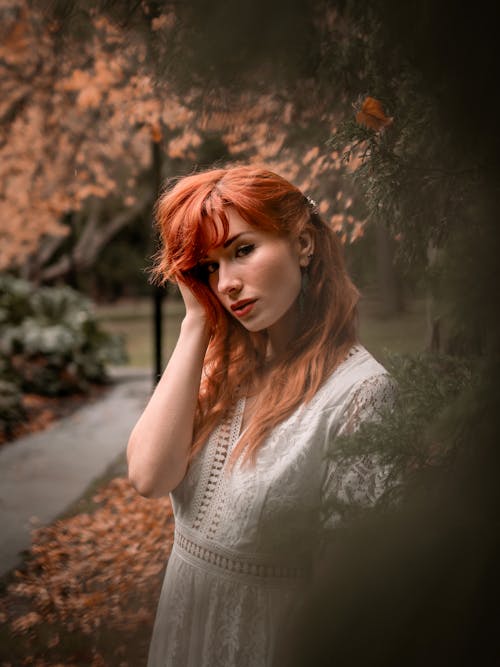 A Pretty Redheaded Woman in White Top Posing