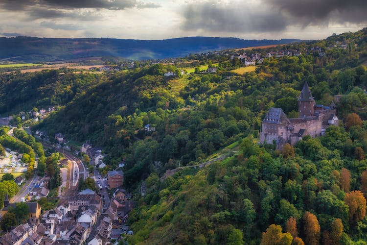 Castle In Forest On Hill Over Town