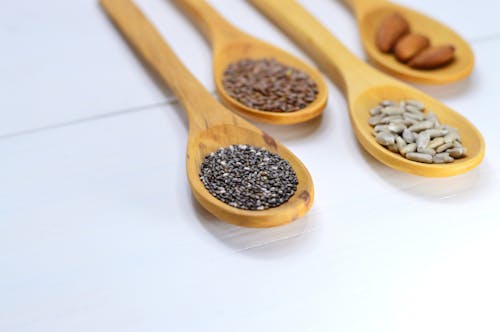 Closeup Photo of Four Brown Wooden Spatulas With Seds