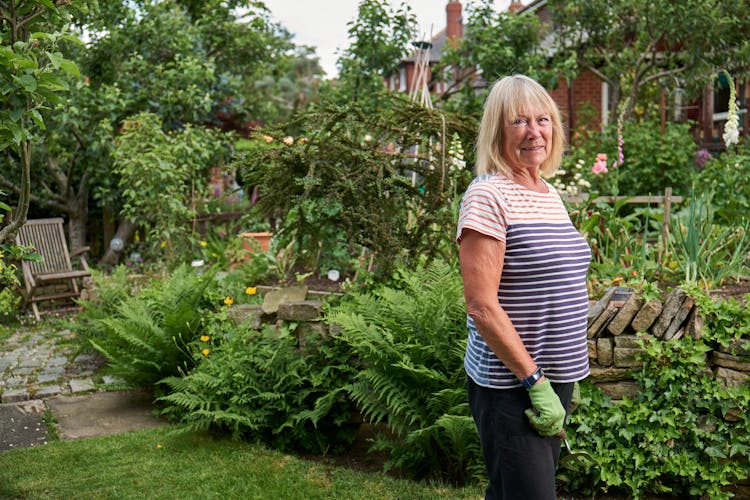 Smiling Senior Woman Working In Green Garden