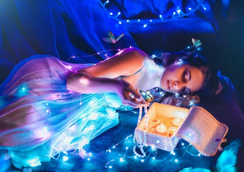 Woman in Blue Dress Lying Down with Christmas Lights