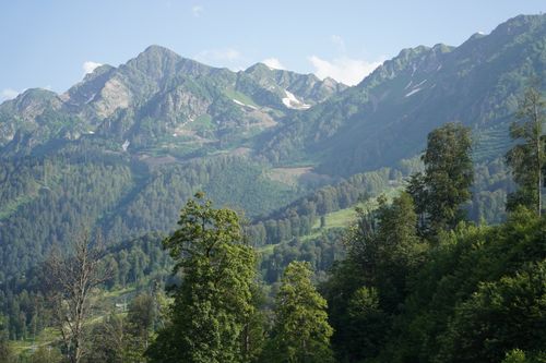 Free Majestic mountain range with lush green valleys under clear blue skies, perfect for nature enthusiasts. Stock Photo