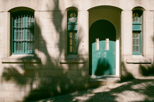 香港岛上有座阳光明媚的石立面建筑，门窗漆成绿色