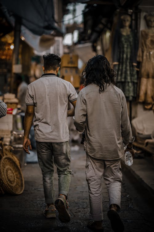 Back View of Two Men Walking on an Alley