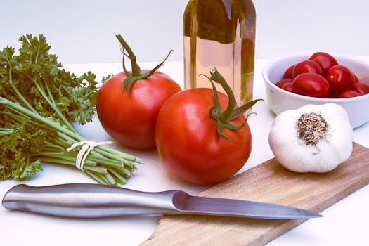 Fresh ingredients for healthy cooking featuring tomatoes, garlic, and herbs on a cutting board.