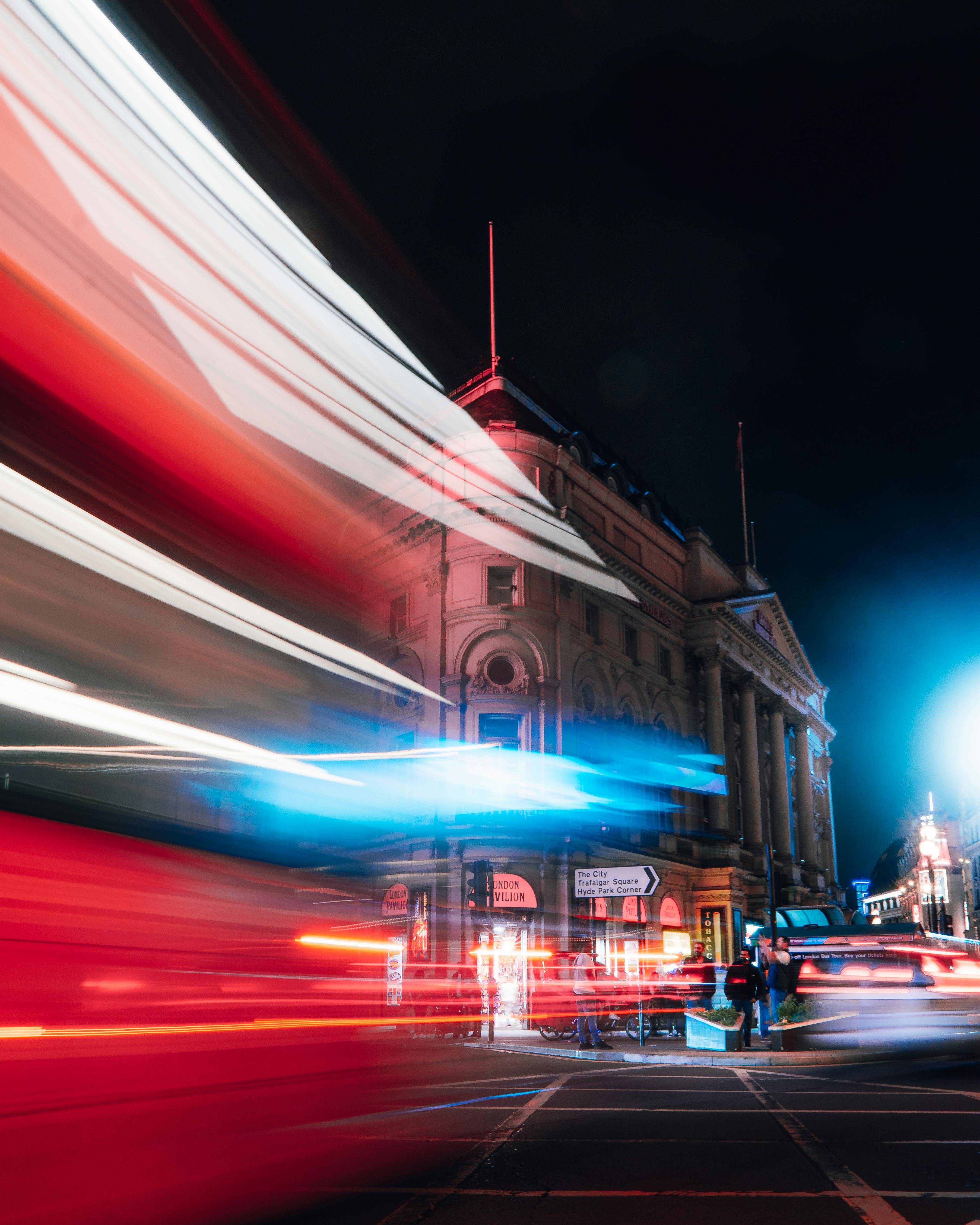 Blurred lights of traffic in central London at night with iconic architecture.