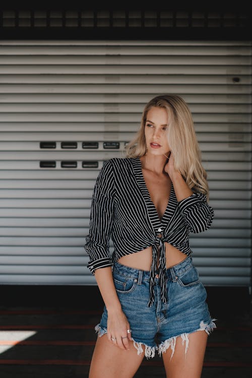 Woman in Black and White Striped Shirt and Blue Denim Shorts Posing