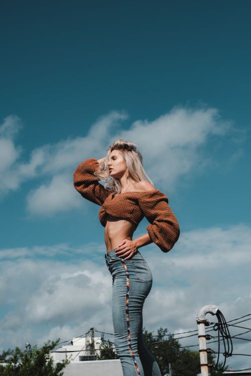 Woman wearing a hazelnut boat-neck sweater with flare jeans