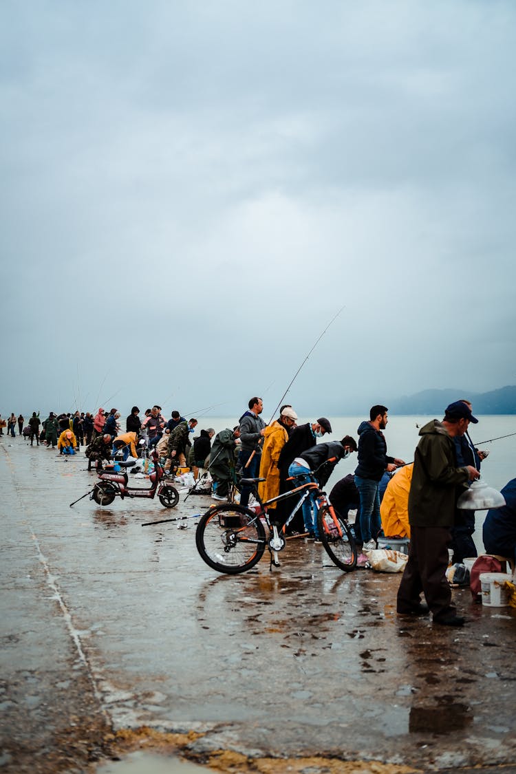 People Lining Up On Shore Fishing