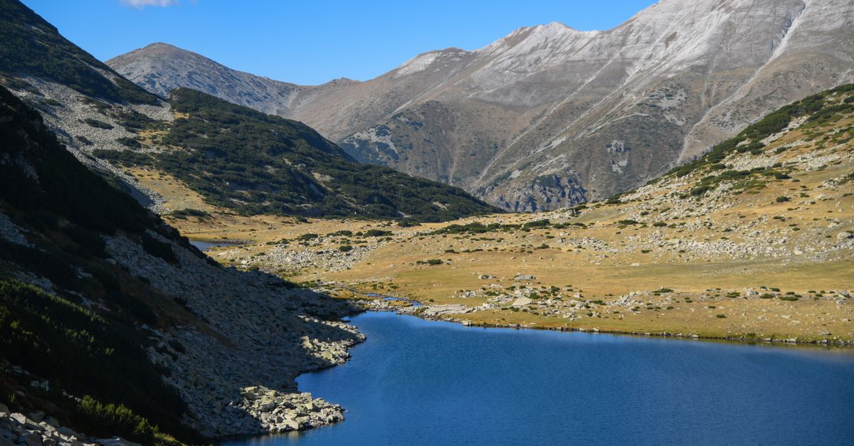 Idyllic alpine lake surrounded by majestic mountain peaks in Pirin National Park, Bulgaria.