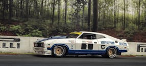 经典福特赛车在森林赛道上飞驰，尽显动感设计