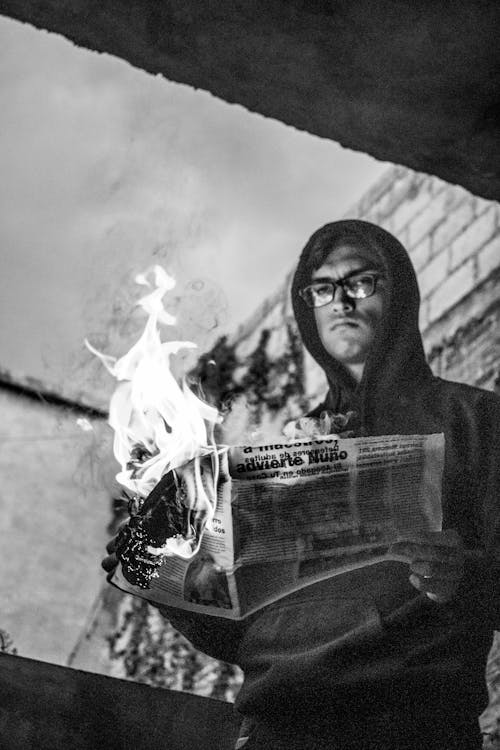 A Man Holding a Burning Newspaper