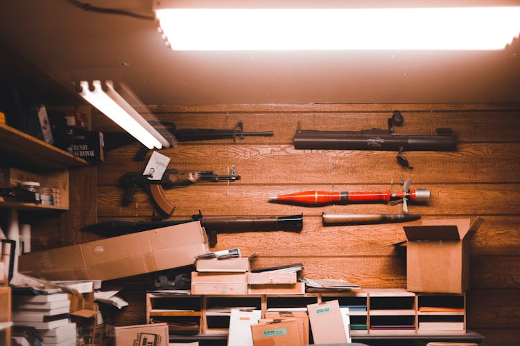 Wooden Shed Interior With Hunting Rifles And Boxes