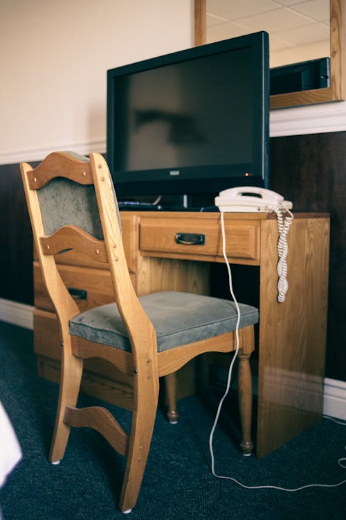 Free A Flat Screen Television on a Wooden Table with Chair Stock Photo