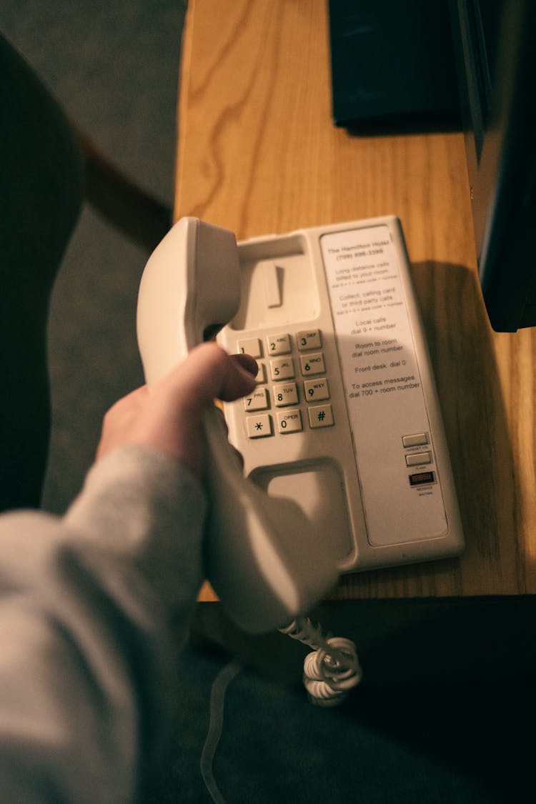 A Person Holding A Landline Phone