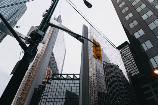 Modern urban skyline featuring towering skyscrapers and a traffic light in downtown Toronto.