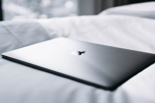 Thin laptop resting on crisp white linens, perfect for minimalistic and modern lifestyle imagery.