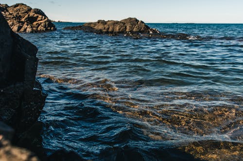 Free A Rock Formation on a Body of Water Stock Photo