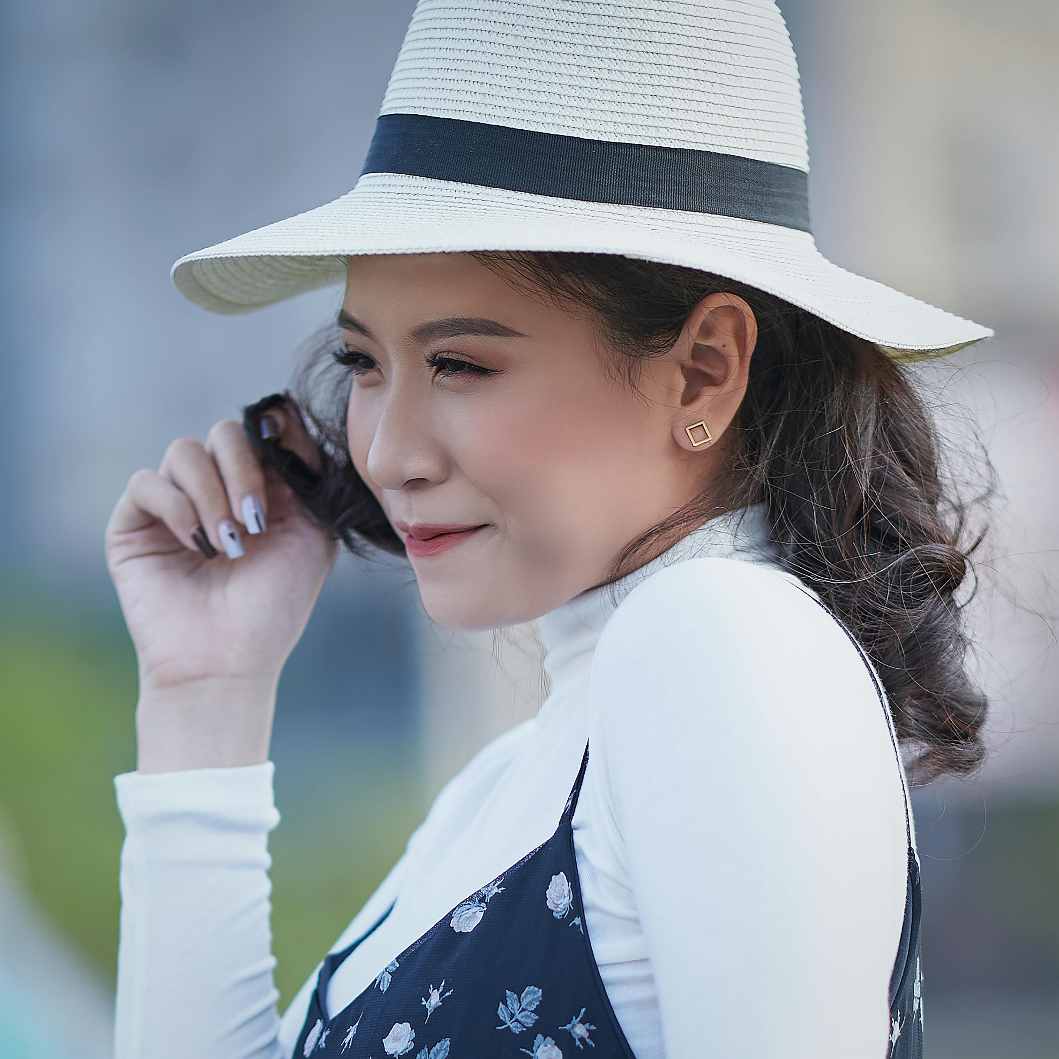 Free Profile of a stylish woman in a wide-brimmed hat, exuding elegance and charm. Stock Photo