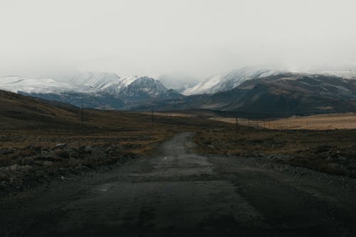 Kostnadsfri bild av bergen, brunt fält, dimmig
