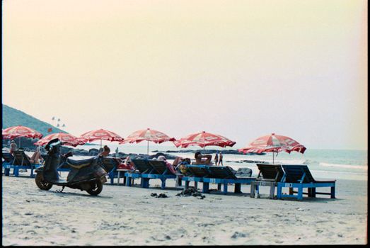 Relaxing beach scene with colorful umbrellas and deckchairs, perfect for vacations.