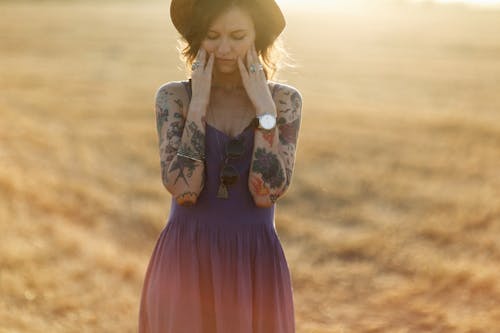 Woman in Blue Dress with Hands on Face