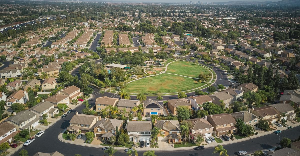 Drone aerial view of a spacious suburban neighborhood with a central park area.