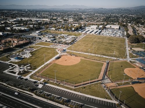 Free Aerial view of urban baseball fields with cityscape in the background, captured during daytime. Stock Photo