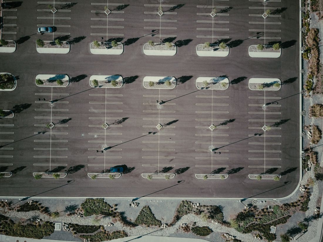 Aerial view of a commercial parking lot with pole lights
