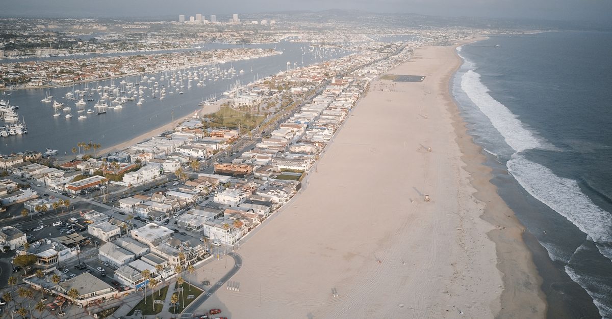 A stunning aerial view showcasing a coastal city with a vast beach and calm seashores.