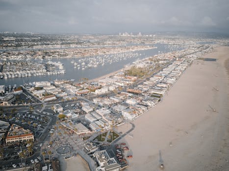 Aerial cityscape showcasing a coastal area with marina and sandy beach.