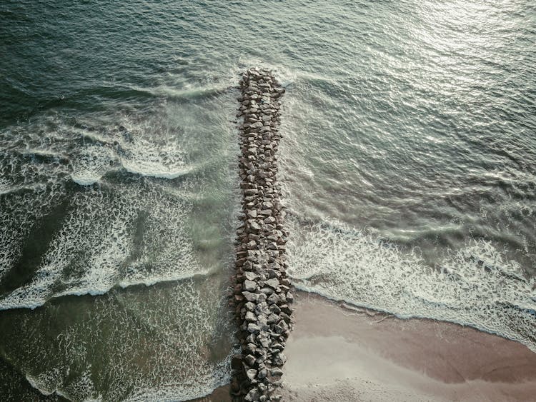 Aerial View Of Breakwater Rocks In The Seashore