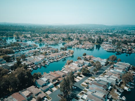 A stunning aerial view of a peaceful residential area with lakes and houses surrounded by greenery.