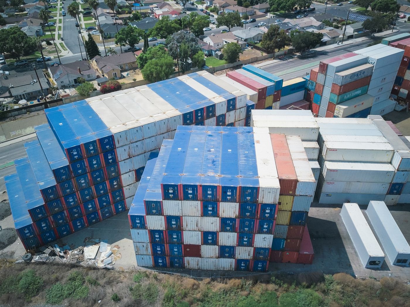 Aerial view of cargo containers beside residential housing