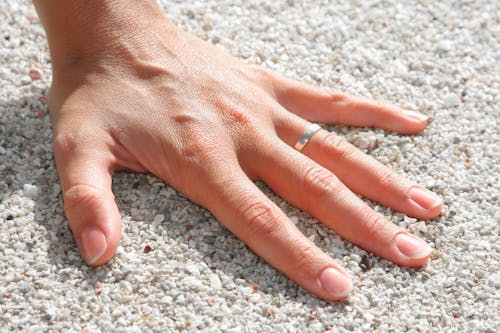 左手人类的手在土壤上戴银戒指