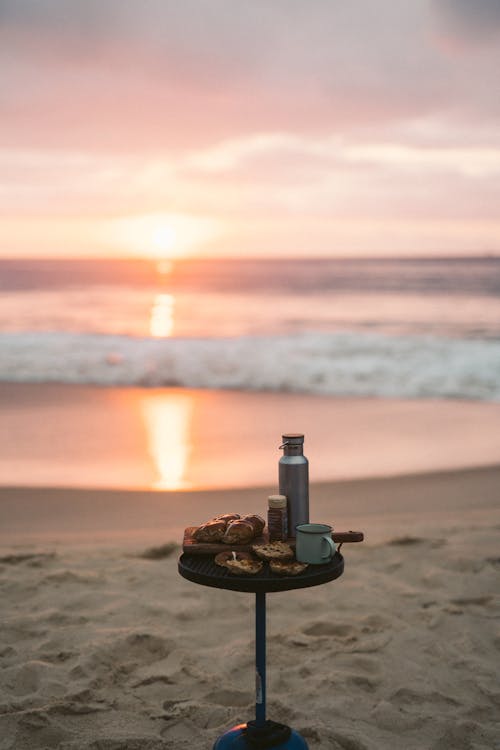Foods on the Small Round Table on the Shore of a Beach