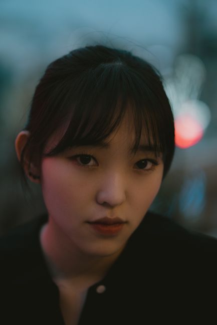 Captivating portrait of a woman at night in Ho Chi Minh City, highlighting her serene expression.