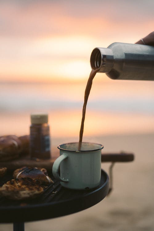 Person Pouring a Drink in a Cup