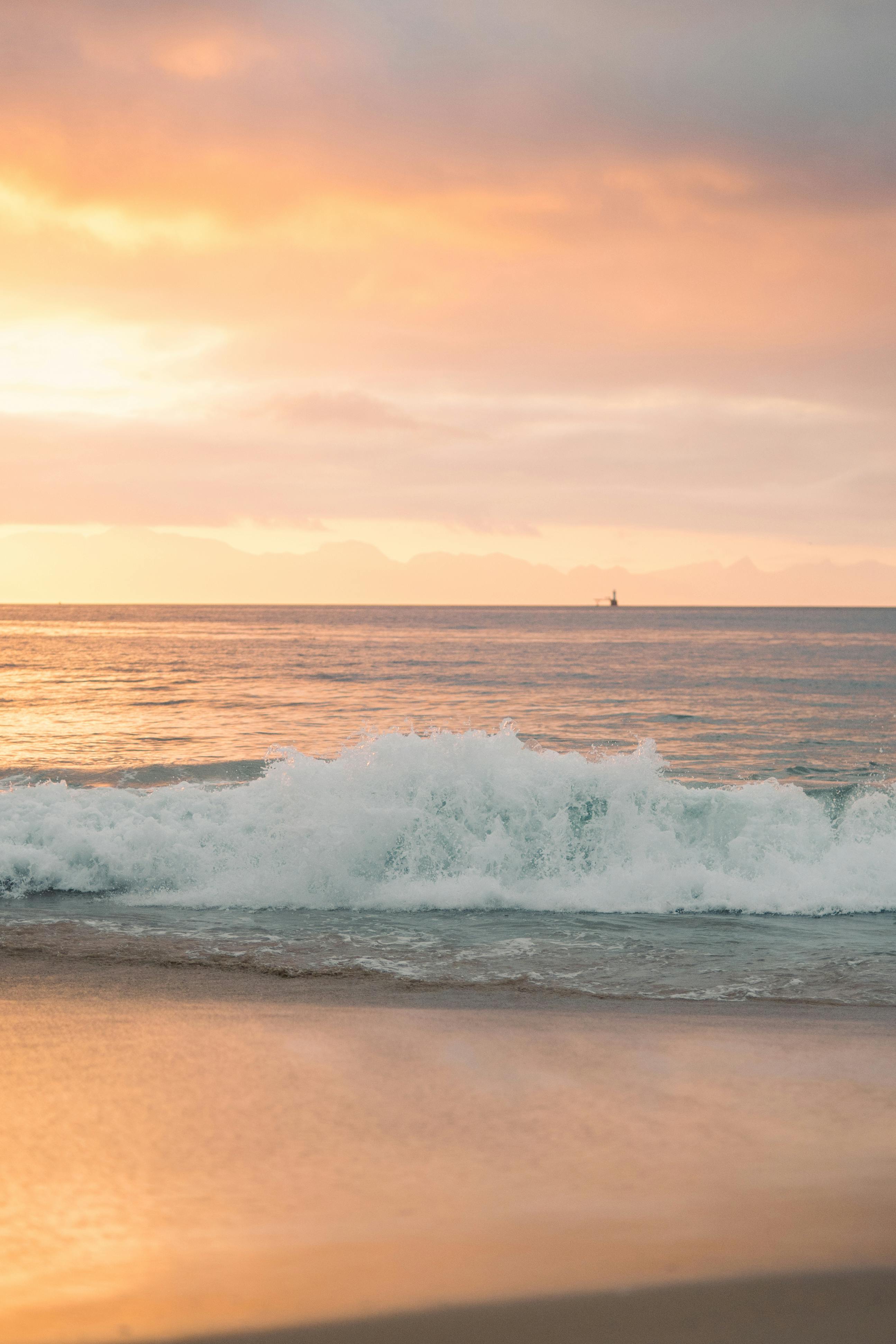 黄金时段捕捉到充满活力的日落天空下美丽的海浪