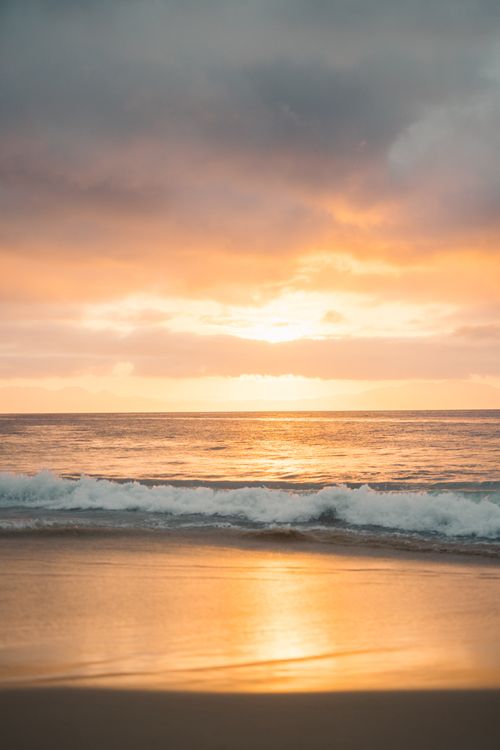 Free Capture of a tranquil beach with vibrant sunset and calming ocean waves, perfect for relaxation themes. Stock Photo
