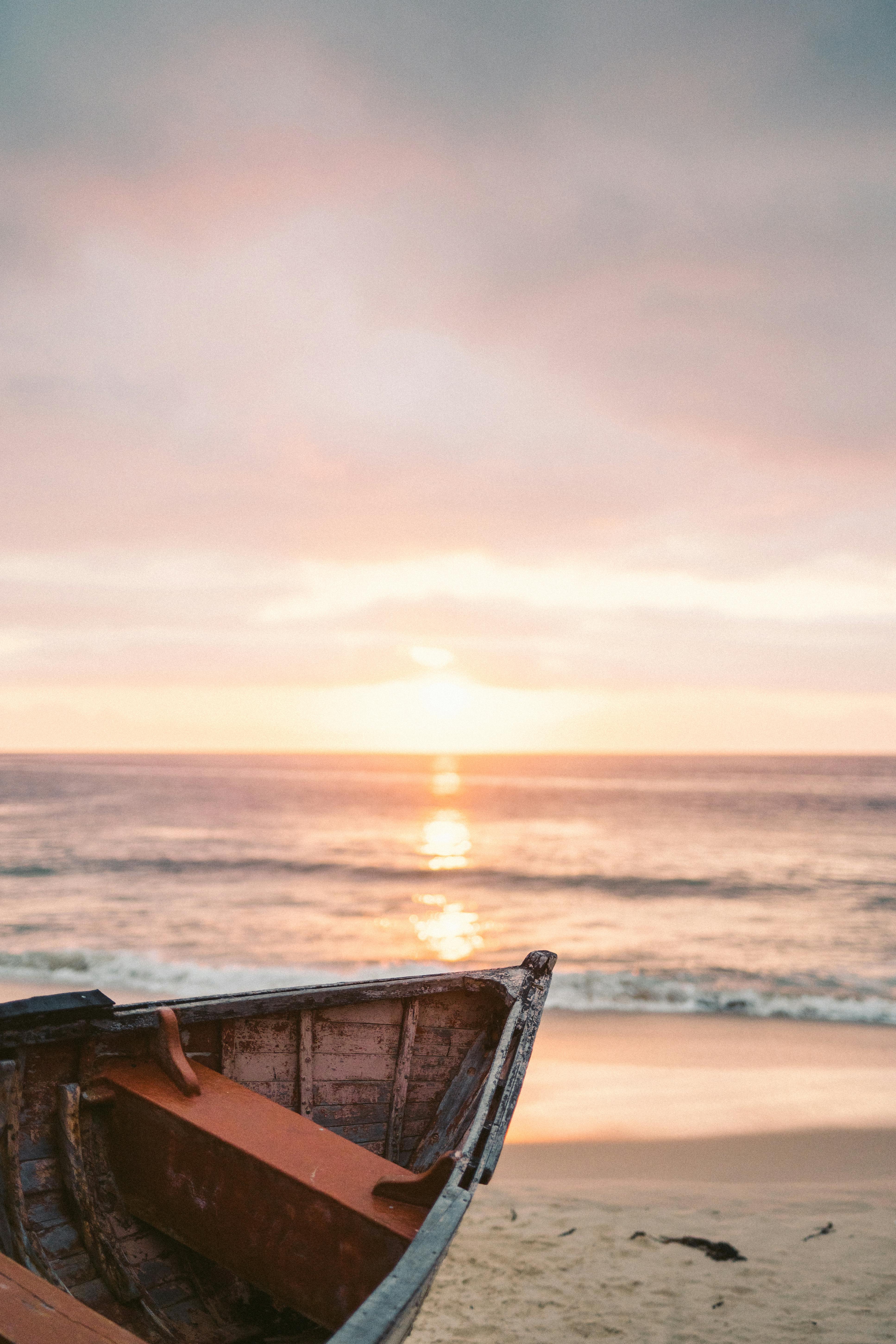 日落时分，沙滩上的一艘独木舟，映照出宁静的海景