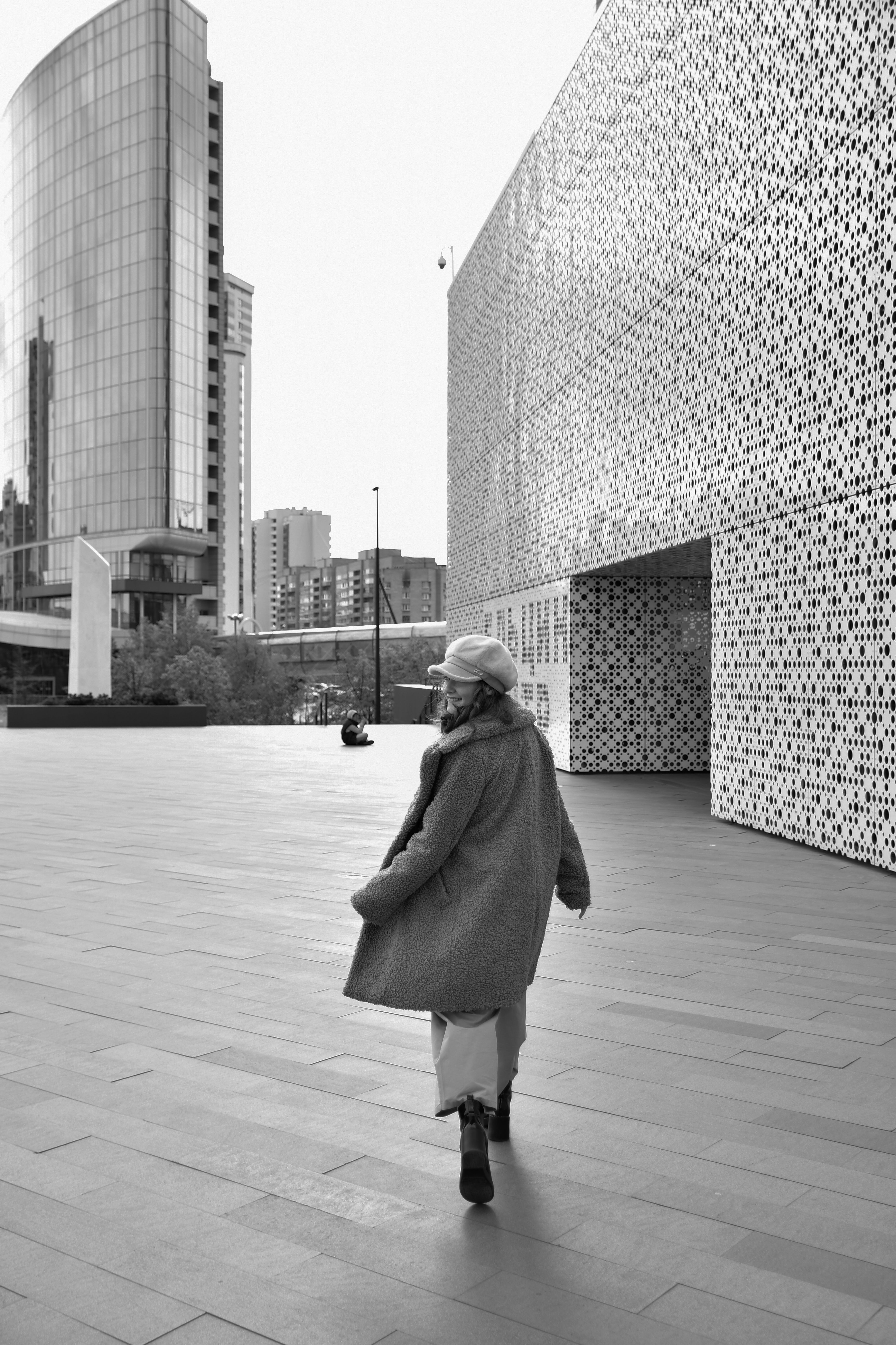 Grayscale Photo of a Woman in a Coat Walking at a City · Free Stock Photo