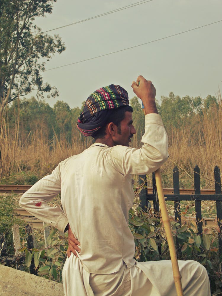 A Man Wearing A Turban And White Long Sleeves