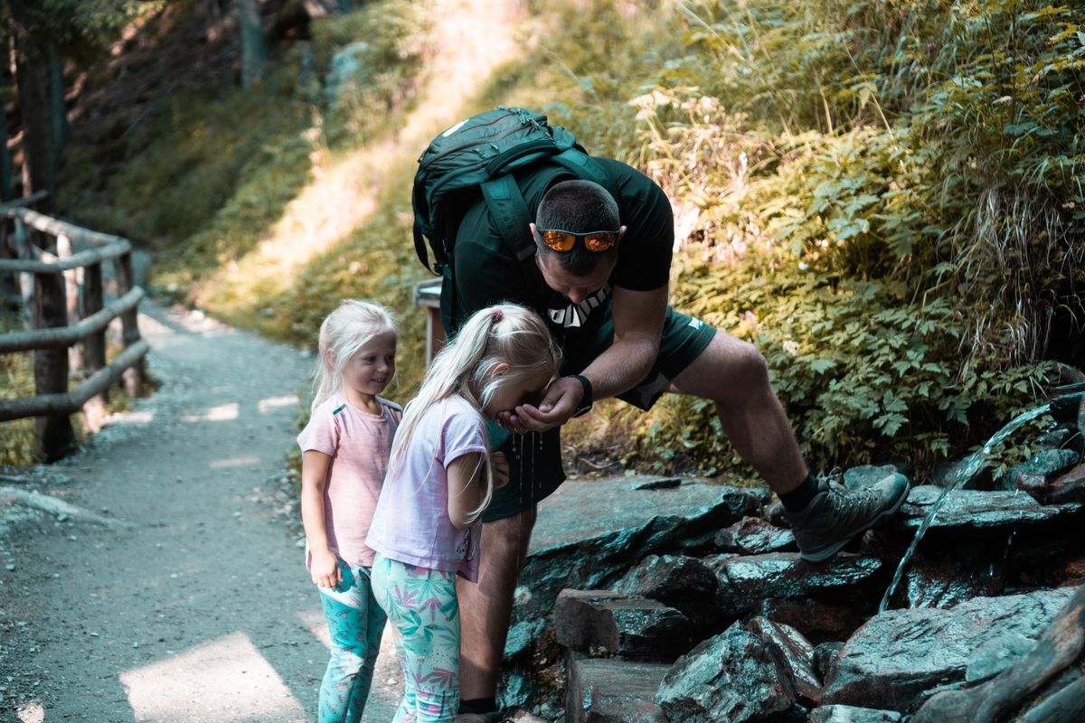 Padre de senderismo con sus hijas — preparación de emergencia familiar con niños