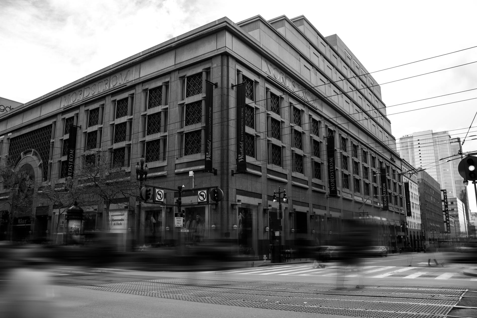 Striking black and white capture of a bustling city street featuring the Nordstrom building.